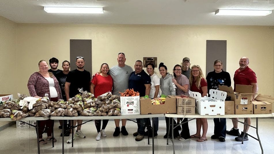 Group of people behind a table full of food donations