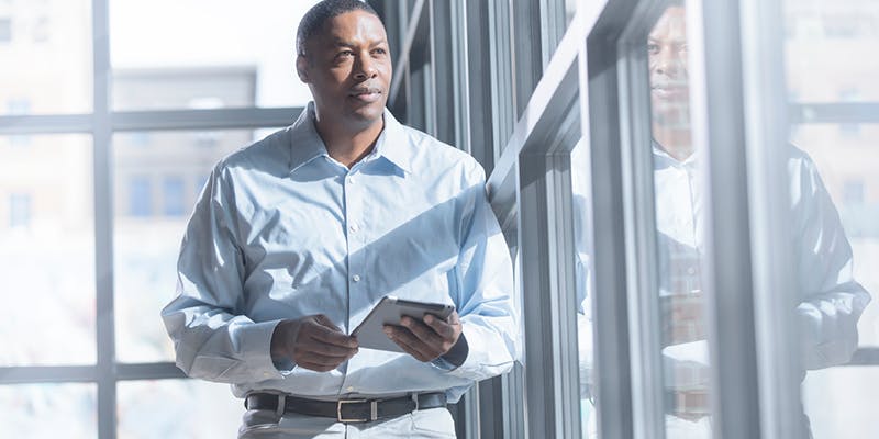 Image of man considering the pros and cons of a percentage vs. flat-fee franchise