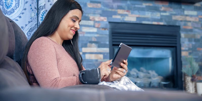 Woman researching how to rebuild credit on a tablet