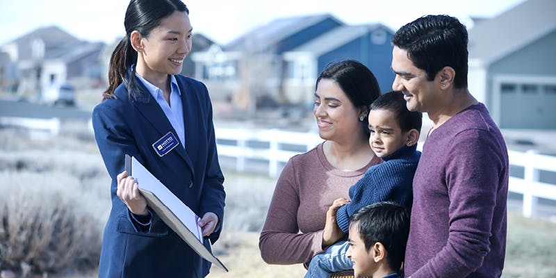 A real estate agent showing a family of 4 details about a new construction home. 