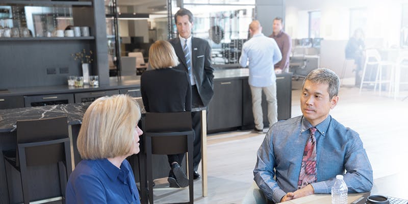 A candid image of a mortgage brokerage, which a mortgage broker speaking to a borrower.