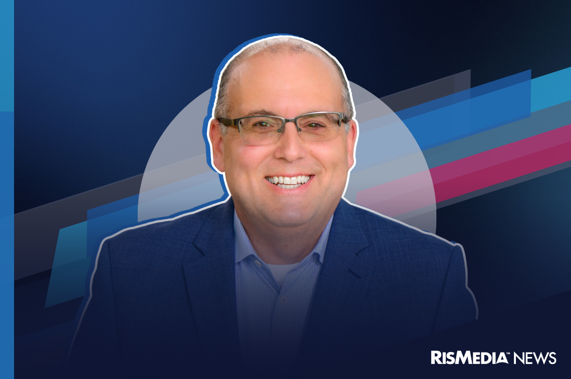 A smiling man in a suit jacket and glasses is centered against a blue abstract background with geometric shapes. The RISMedia News logo appears in the lower right corner.